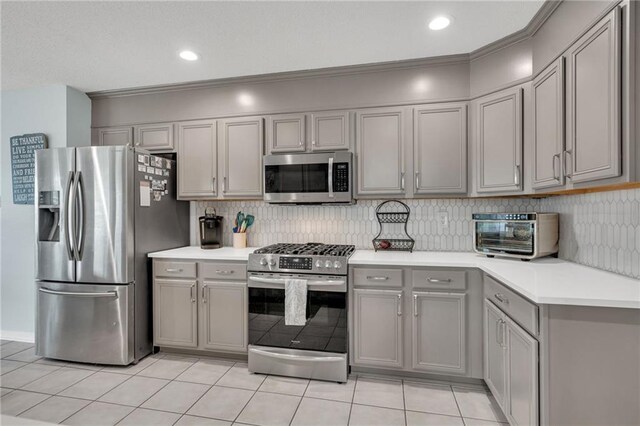 497 Jj Ln, Covington, LA 70433 - kitchen featuring appliances with stainless steel finishes, gray cabinetry, light tile patterned floors, light countertops, and recessed lighting