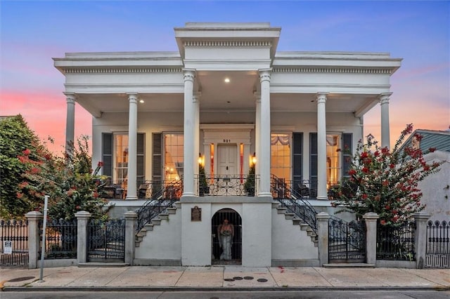 521 Dauphine St, New Orleans, LA 70112 - view of front facade with stairway, covered porch, a fenced front yard, and a gate