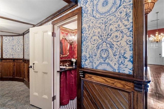 521 Dauphine St, New Orleans, LA 70112 - bathroom with a wainscoted wall, ornamental molding, a chandelier, wallpapered walls, and wood finished floors