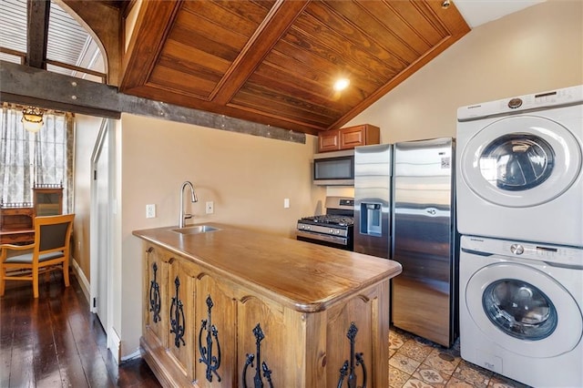 521 Dauphine St, New Orleans, LA 70112 - kitchen featuring stainless steel appliances, stacked washer / drying machine, wood ceiling, vaulted ceiling, and a peninsula