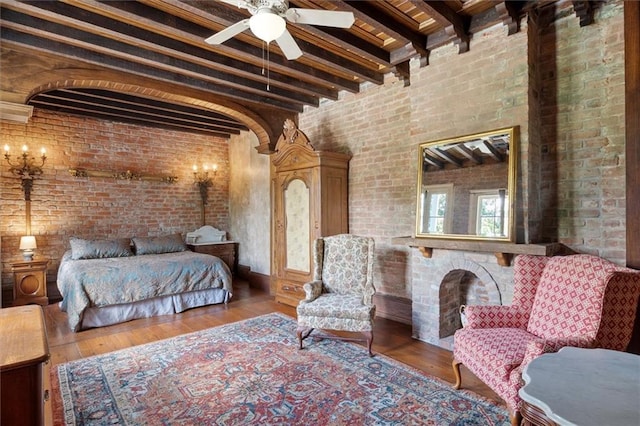 521 Dauphine St, New Orleans, LA 70112 - bedroom featuring beamed ceiling, brick wall, hardwood / wood-style flooring, and a fireplace