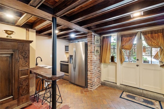521 Dauphine St, New Orleans, LA 70112 - basement featuring stainless steel refrigerator with ice dispenser, brick floors, and wood ceiling