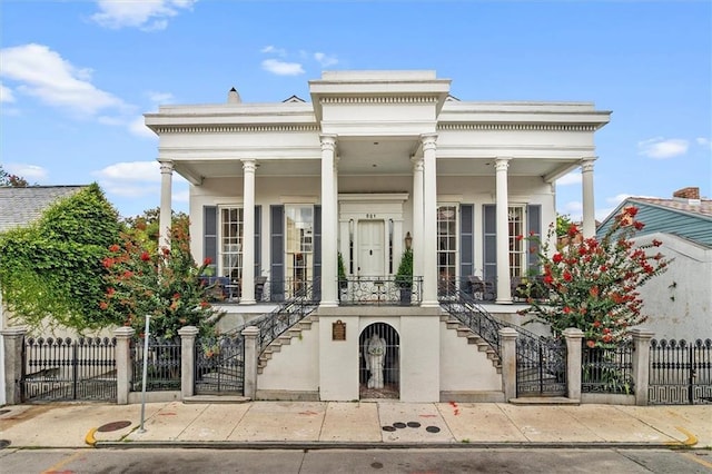 521 Dauphine St, New Orleans, LA 70112 - greek revival inspired property with a porch, stairs, a gate, and a fenced front yard