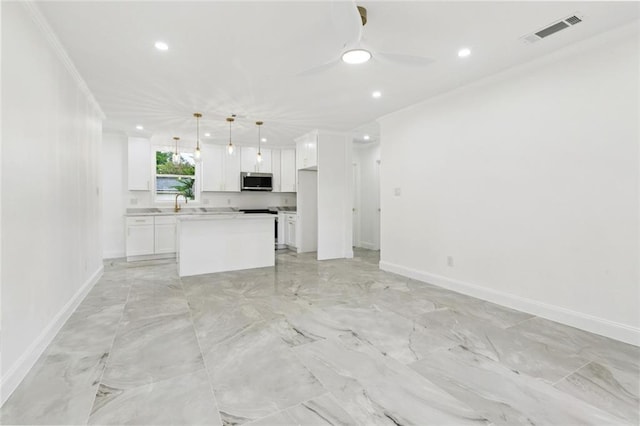 541 Jefferson Park Ave, Jefferson, LA 70121 - kitchen featuring stainless steel microwave, open floor plan, recessed lighting, white cabinetry, and a center island