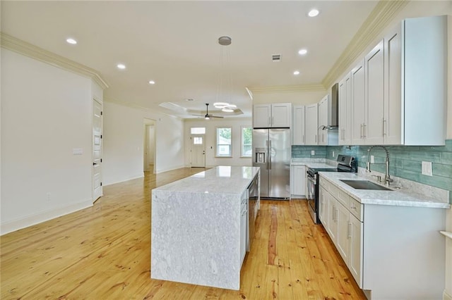 6032 Wingate Dr, New Orleans, LA 70122 - kitchen featuring stainless steel appliances, a kitchen island, ornamental molding, light wood-type flooring, and a ceiling fan