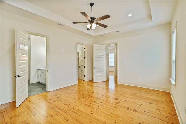 6032 Wingate Dr, New Orleans, LA 70122 - unfurnished bedroom with a raised ceiling, light wood-type flooring, multiple windows, and recessed lighting