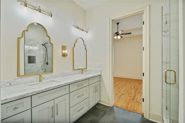 6032 Wingate Dr, New Orleans, LA 70122 - bathroom featuring a ceiling fan, a marble finish shower, double vanity, and wood finished floors