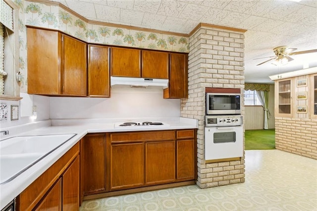 953 Homestead Ave, Metairie, LA 70005 - kitchen with white appliances, under cabinet range hood, ceiling fan, light countertops, and brown cabinetry