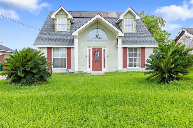 638 Colony Park Dr, La Place, LA 70068 - view of front of home with roof with shingles, brick siding, solar panels, and a front yard