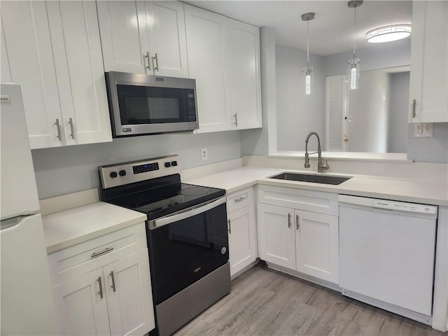 3320 N Arnoult Rd Unit 109, Metairie, LA 70002 - kitchen featuring stainless steel appliances, white cabinets, light countertops, light wood-type flooring, and decorative light fixtures