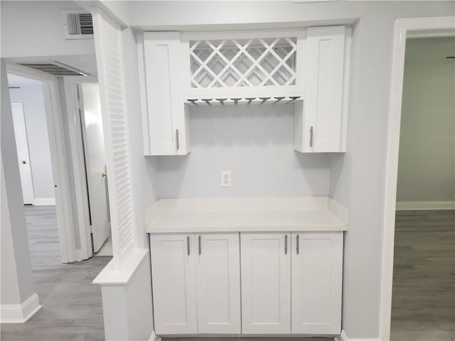 3320 N Arnoult Rd Unit 109, Metairie, LA 70002 - kitchen featuring white cabinets, light wood finished floors, and light countertops