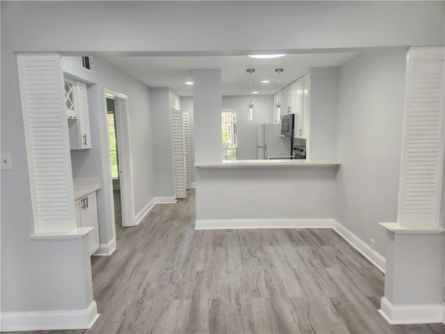 3320 N Arnoult Rd Unit 109, Metairie, LA 70002 - kitchen with white cabinetry, light wood finished floors, light countertops, freestanding refrigerator, and recessed lighting