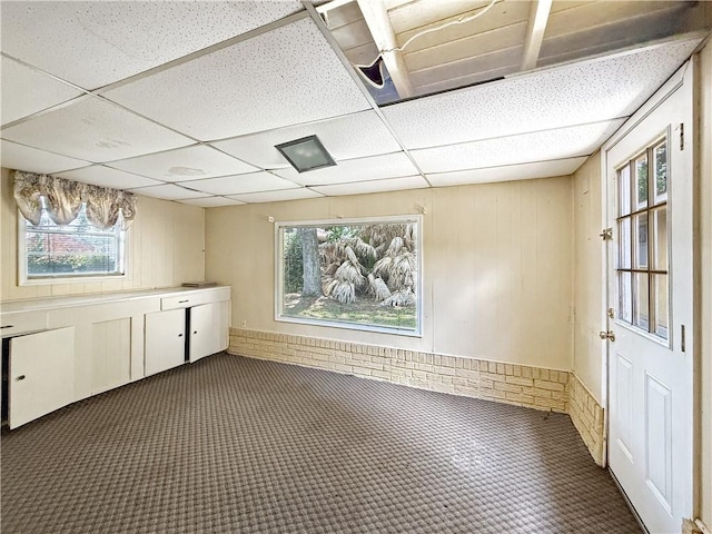 1593 Eastridge Dr, Slidell, LA 70458 - below grade area featuring a paneled ceiling, healthy amount of natural light, and wood walls