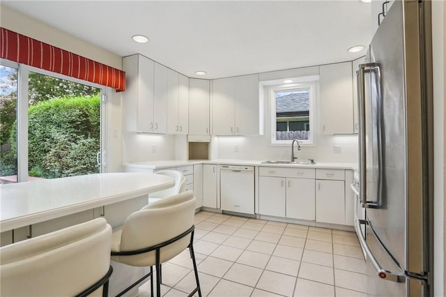 2310 Metairie Ct, Metairie, LA 70001 - kitchen featuring freestanding refrigerator, dishwasher, light countertops, white cabinetry, and tasteful backsplash