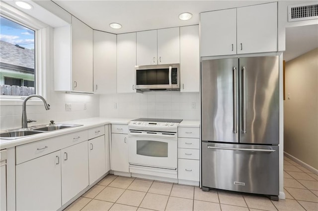 2310 Metairie Ct, Metairie, LA 70001 - kitchen with stainless steel appliances, light countertops, white cabinets, tasteful backsplash, and light tile patterned flooring