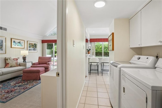 2310 Metairie Ct, Metairie, LA 70001 - laundry room featuring washing machine and clothes dryer, light tile patterned flooring, and cabinet space