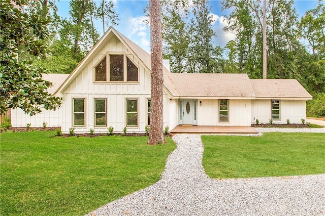 106 Woodlawn Ln, Mandeville, LA 70471 - view of front facade with board and batten siding, a front lawn, roof with shingles, and a chimney
