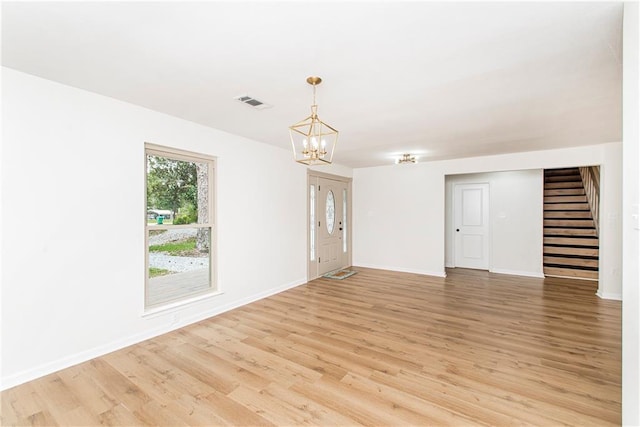 106 Woodlawn Ln, Mandeville, LA 70471 - unfurnished room with stairway, light wood finished floors, and a chandelier