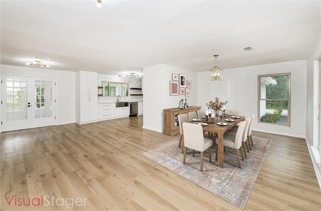 106 Woodlawn Ln, Mandeville, LA 70471 - dining area featuring a chandelier, light wood-style floors, healthy amount of natural light, and french doors