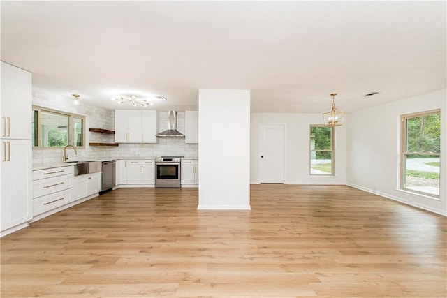 106 Woodlawn Ln, Mandeville, LA 70471 - kitchen with stainless steel appliances, wall chimney range hood, a chandelier, backsplash, and white cabinetry