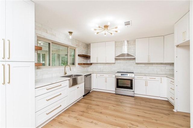 106 Woodlawn Ln, Mandeville, LA 70471 - kitchen featuring wall chimney range hood, appliances with stainless steel finishes, decorative backsplash, and white cabinetry