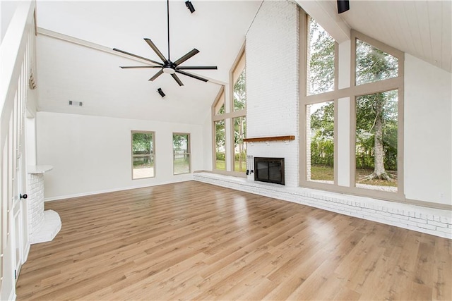 106 Woodlawn Ln, Mandeville, LA 70471 - unfurnished living room with high vaulted ceiling, a brick fireplace, ceiling fan, and light wood-type flooring