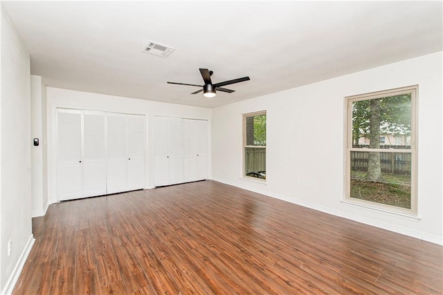 106 Woodlawn Ln, Mandeville, LA 70471 - unfurnished bedroom with two closets, dark wood-style floors, and ceiling fan