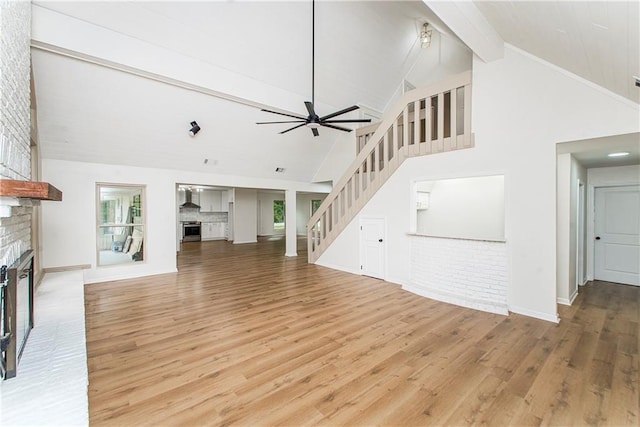 106 Woodlawn Ln, Mandeville, LA 70471 - unfurnished living room featuring a brick fireplace, beamed ceiling, stairway, light wood-style floors, and ceiling fan