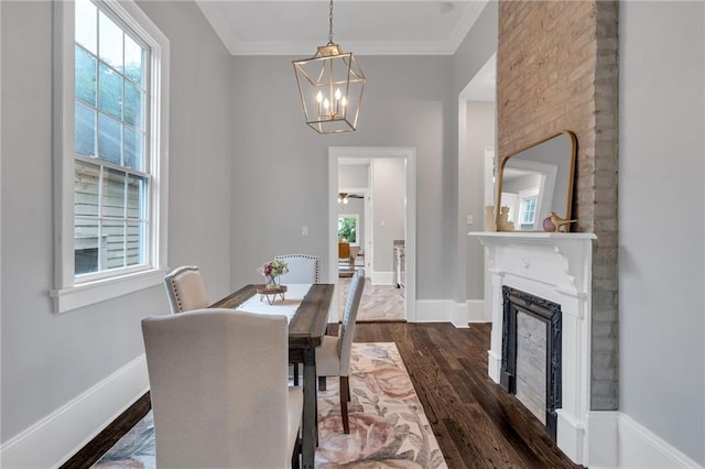 2625 Ursulines Ave, New Orleans, LA 70119 - dining area featuring healthy amount of natural light, dark wood-type flooring, a chandelier, a fireplace, and crown molding