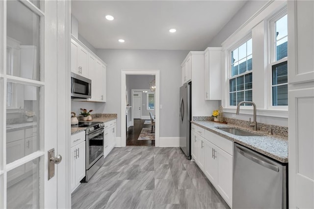 2625 Ursulines Ave, New Orleans, LA 70119 - kitchen with stainless steel appliances, white cabinetry, light stone countertops, and recessed lighting