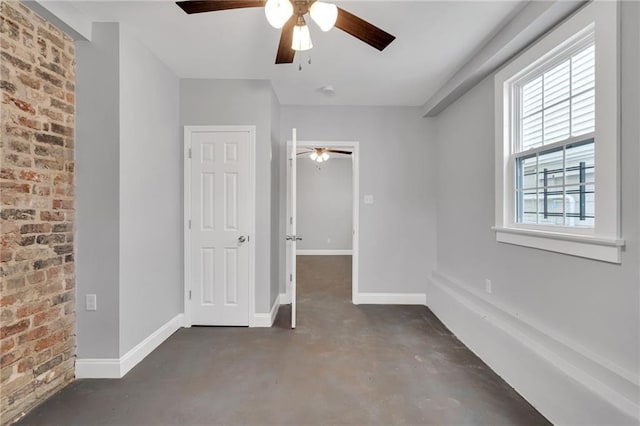 2625 Ursulines Ave, New Orleans, LA 70119 - unfurnished bedroom featuring finished concrete flooring, brick wall, and a ceiling fan
