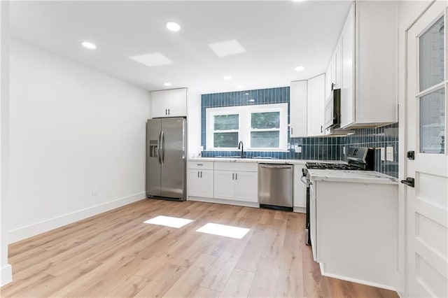 566 Gelpi Ave, Jefferson, LA 70121 - kitchen with appliances with stainless steel finishes, tasteful backsplash, white cabinets, light wood-style flooring, and recessed lighting