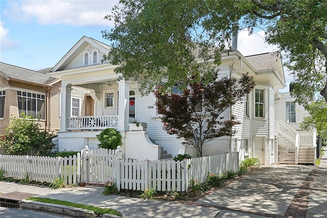 5540 Pitt St, New Orleans, LA 70115 - greek revival house featuring a porch, stairway, a fenced front yard, and roof with shingles