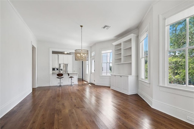 5540 Pitt St, New Orleans, LA 70115 - unfurnished living room featuring a chandelier, healthy amount of natural light, dark wood-type flooring, and ornamental molding