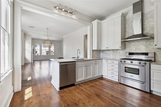 5540 Pitt St, New Orleans, LA 70115 - kitchen featuring stainless steel appliances, wall chimney range hood, a chandelier, and decorative backsplash