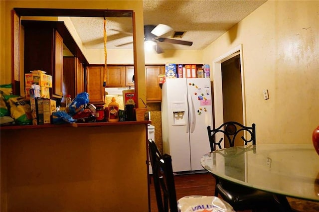 110 E Green St, Hammond, LA 70403 - kitchen featuring white refrigerator with ice dispenser, a textured ceiling, brown cabinets, a peninsula, and dark wood-type flooring