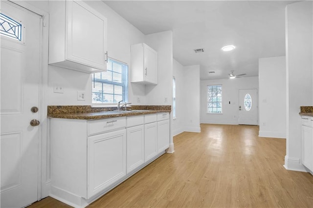 6501 Selma St, New Orleans, LA 70126 - kitchen featuring dark countertops, white cabinetry, ceiling fan, and light wood finished floors