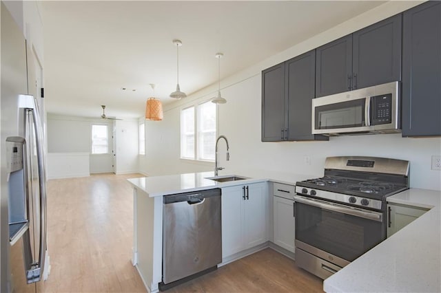 414345 Ulloa St, New Orleans, LA 70119 - kitchen featuring stainless steel appliances, a peninsula, light wood-style flooring, and plenty of natural light