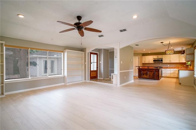 808 N Pearl St, Slidell, LA 70461 - unfurnished living room featuring light wood-type flooring, ceiling fan, arched walkways, and recessed lighting