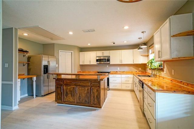808 N Pearl St, Slidell, LA 70461 - kitchen with stainless steel appliances, light wood finished floors, white cabinetry, recessed lighting, and a center island