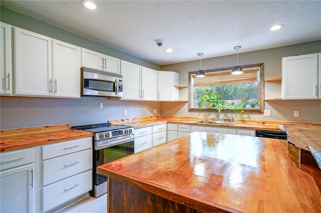 808 N Pearl St, Slidell, LA 70461 - kitchen with appliances with stainless steel finishes, butcher block counters, open shelves, white cabinetry, and a textured ceiling