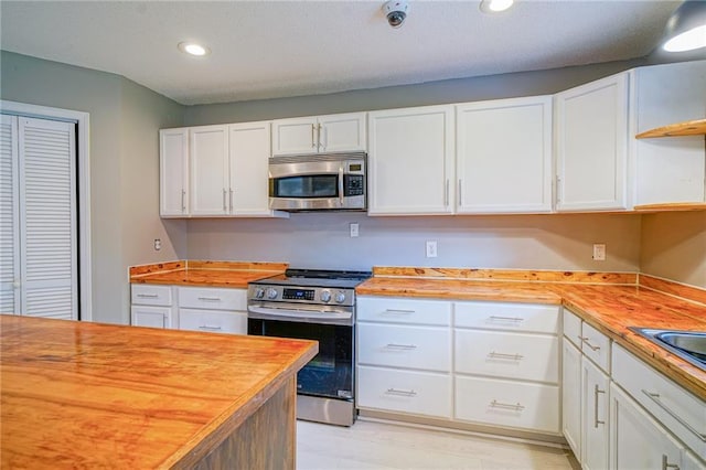 808 N Pearl St, Slidell, LA 70461 - kitchen featuring appliances with stainless steel finishes, butcher block counters, open shelves, white cabinets, and recessed lighting