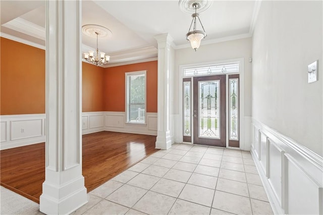 804 S Hawthorn Ct, Slidell, LA 70458 - entryway with ornate columns, ornamental molding, a decorative wall, light wood-style flooring, and a chandelier