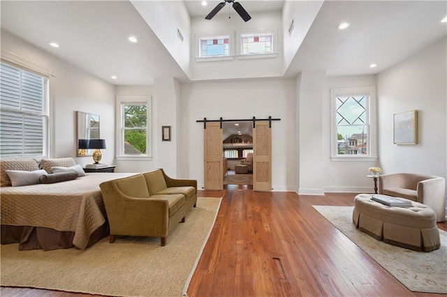 208 S Scott St, New Orleans, LA 70119 - bedroom with hardwood / wood-style floors, recessed lighting, a high ceiling, a barn door, and ceiling fan