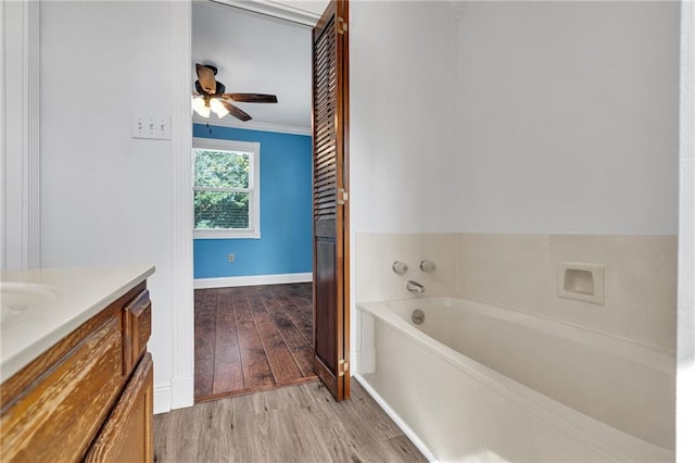 2412 Green Acres Rd, Metairie, LA 70003 - bathroom with wood finished floors, a bath, vanity, a ceiling fan, and ornamental molding