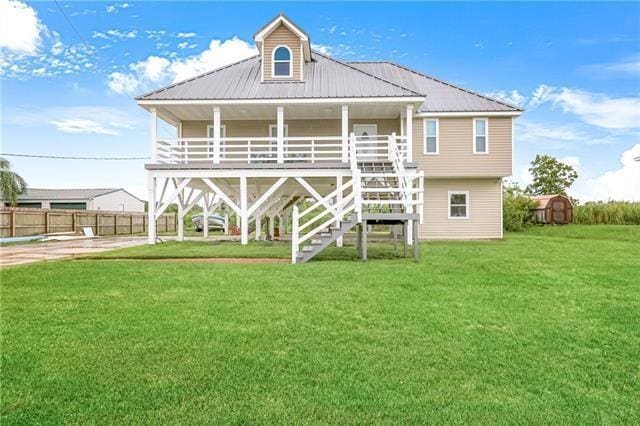 5080 Betty Mae St, Lafitte, LA 70067 - back of house with a yard, a metal roof, a porch, and stairs