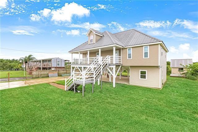 5080 Betty Mae St, Lafitte, LA 70067 - back of house featuring a yard, a metal roof, stairway, and a porch