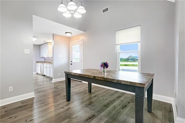 5080 Betty Mae St, Lafitte, LA 70067 - dining room featuring a chandelier, plenty of natural light, and dark wood finished floors
