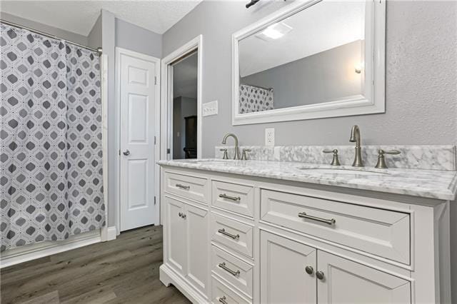 5080 Betty Mae St, Lafitte, LA 70067 - full bathroom with double vanity, wood finished floors, and curtained shower