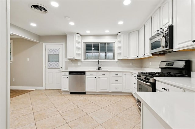 1221 Brockenbraugh Ct, Metairie, LA 70005 - kitchen with appliances with stainless steel finishes, open shelves, light countertops, white cabinets, and recessed lighting